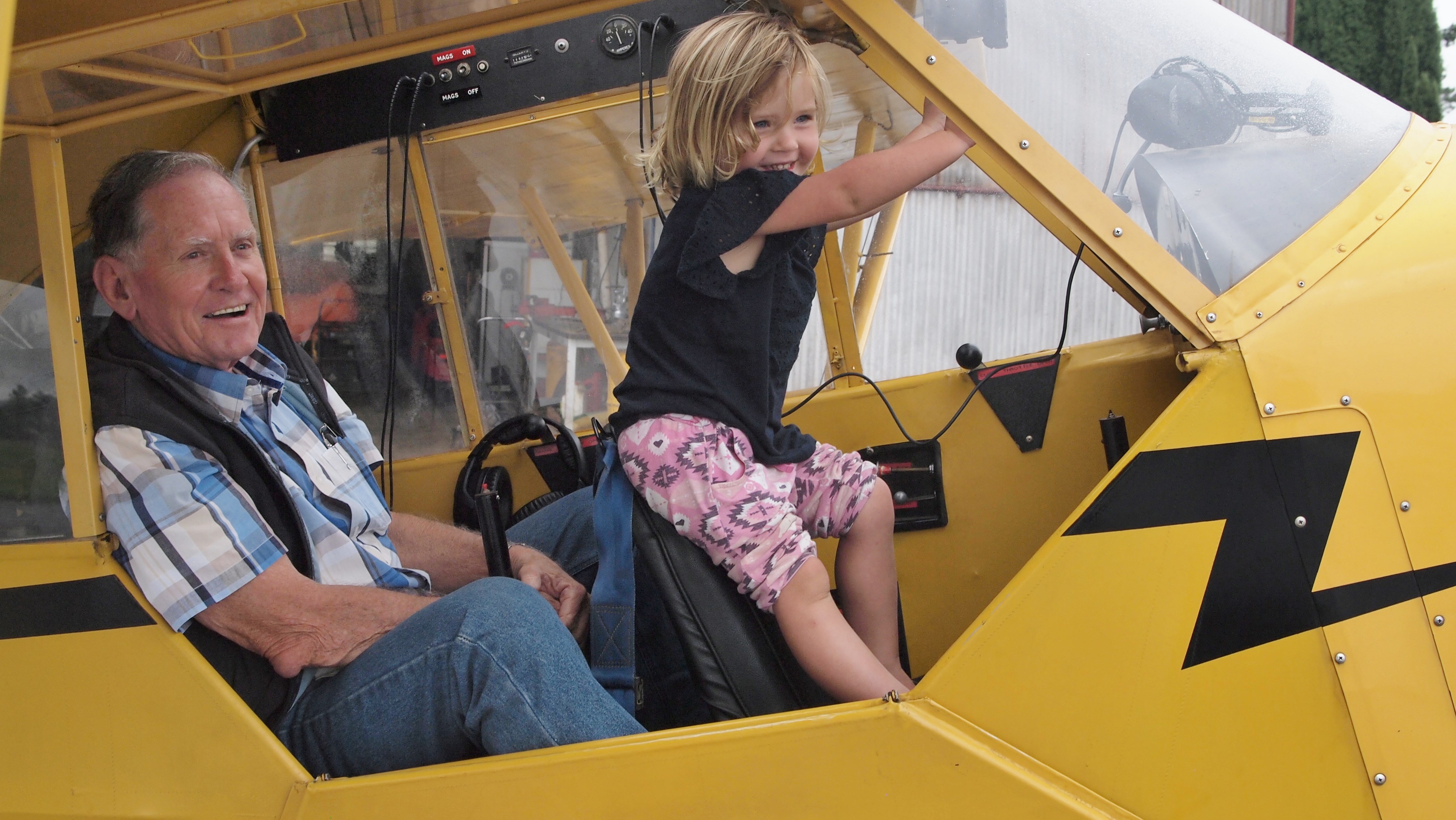 Bill with great grand daughter Lily. They are  in the cockpit of the vintage Piper Cub which was the same one in which Bill made his first flight  50 years ago to the day